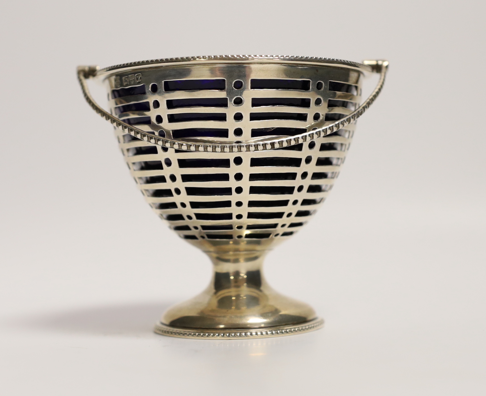 A George V pierced silver sugar vase, with blue glass liner, Barker Brothers, Chester, 1910, height 85mm.